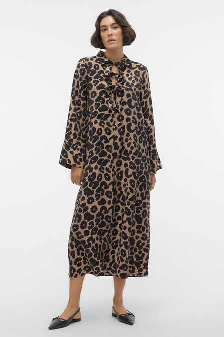 Lange beige jurk van VERO MODA® met zwarte luipaardprint, lange mouwen en strikdetail bij de hals.
