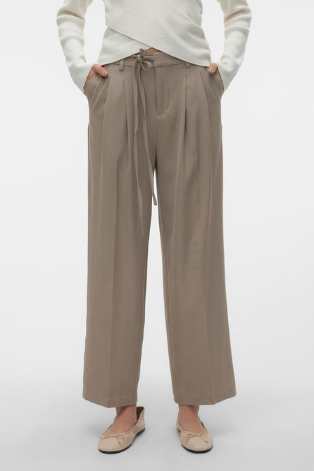Pantalon beige de VERO MODA, vu de de derrière, associé à une chemise crème et des chaussures plates.