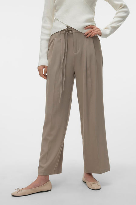 Pantalon beige de VERO MODA® avec une taille haute et une ceinture élastiquée, associé à un haut crème et des ballerinas.