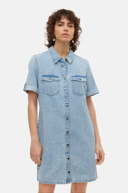 Jupe en denim bleu clair à manches courtes de VERO MODA, avec fermeture à boutons et poches poitrine.