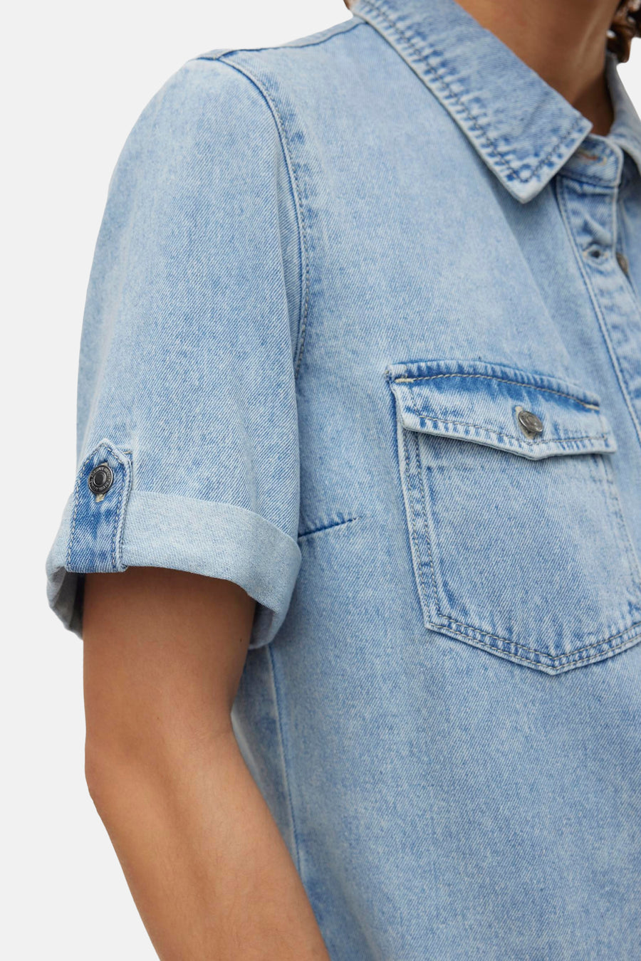 Jean bleu clair à manches courtes de VERO MODA, avec une poche poitrine et des manches.