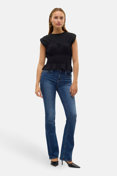 Jean flare bleu marine de VERO MODA, associé à une chemise noire et des escarpins noirs.
