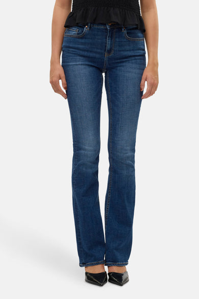 Jean flare bleu marine de VERO MODA avec une texture denim classique et des chaussures noires.