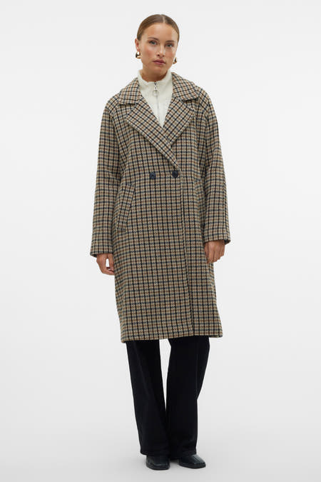 Manteau long marron de VERO MODA, avec un motif à carreaux et porté sur une chemise blanche et un pantalon noir.