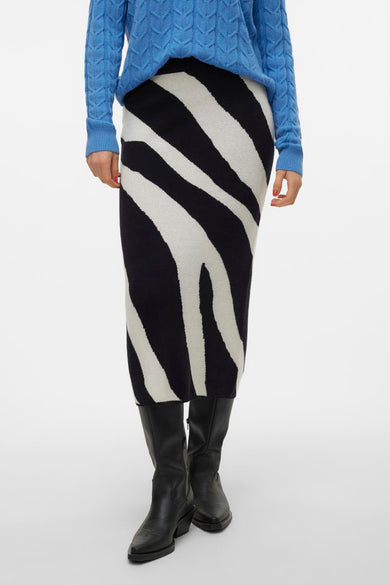 Jupe longue en imprimé zèbre noir, de VERO MODA, portée avec un gilet bleu et des bottes noires, vue arrière.
