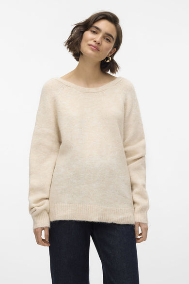 Gilet beige avec col rond de VERO MODA, porté avec des jeans foncés et des boucles d'oreilles dorées.