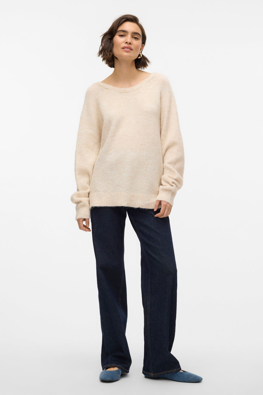 Gilet rond beige de VERO MODA®, porté avec des jeans bleu marine et des chaussures plates.