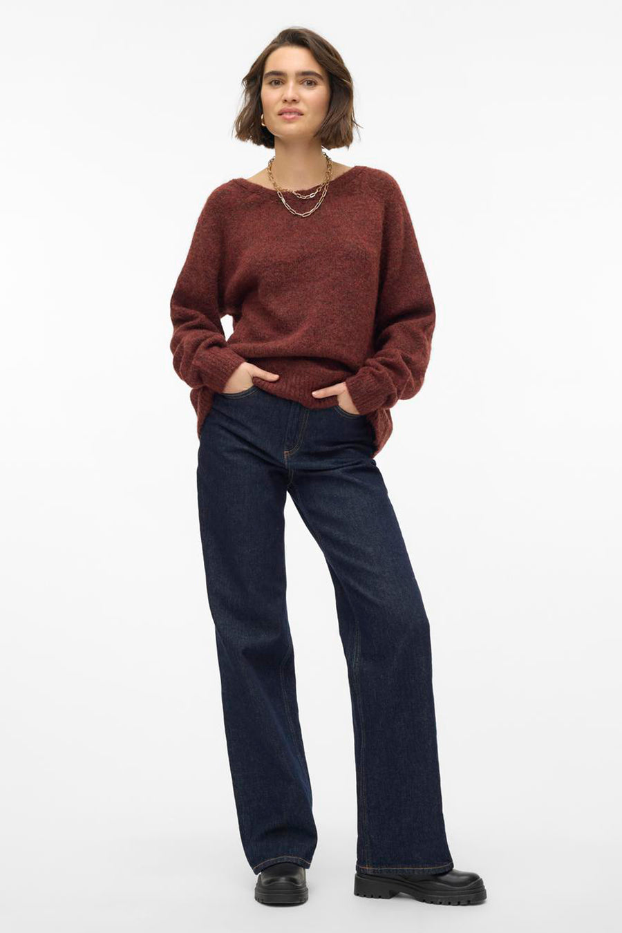 Pull marron avec col rond de VERO MODA®, porté avec des jeans bleus marine et des chaînes d'or.