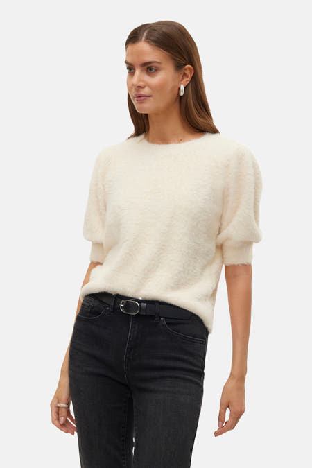 Sweat-shirt écru avec col rond de Vero Moda, à manches courtes, associé à des jeans noirs et une ceinture.