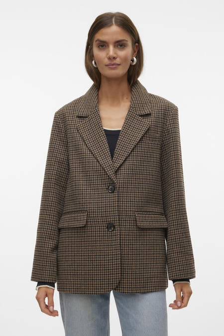 Blazer marron de VERO MODA®, avec un motif à carreaux, porté avec une chemise noire, des jeans bleus et des chaussures noires.