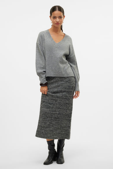 Lange zwarte rok van VERO MODA®, gecombineerd met een grijze trui en zwarte laarzen.
