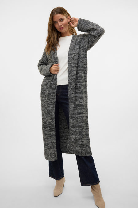 Gilet noir de VERO MODA, porté sur un chemisier blanc et des jeans foncés, avec des bottines en cuir de Suède.