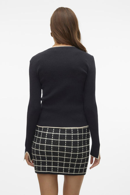 Gilet noir de VERO MODA, avec des manches longues et une minirok à carreaux.