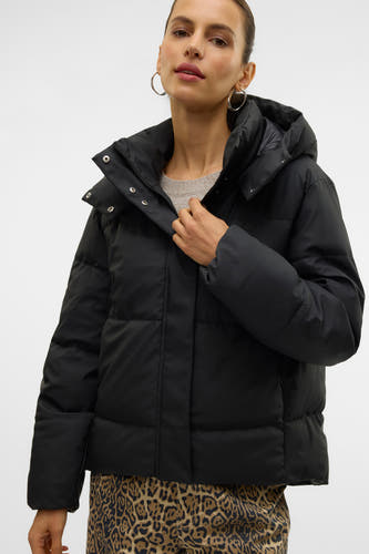 Manteau court noir de Vero Moda, avec capuche et boutons imprimés en argent, porté sur un pantalon à imprimé tigre.