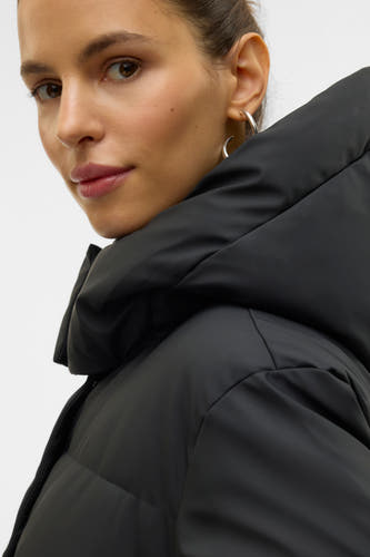 Manteau noir de VERO MODA, avec une grande col et des boucles d'oreilles argentées portées par le modèle.