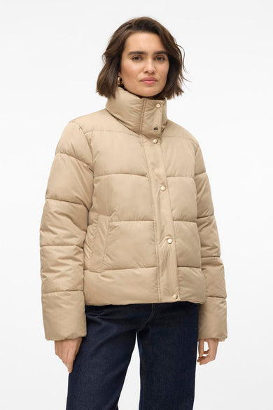 Manteau court beige de Vero Moda, vu de l'arrière, combiné avec des jeans foncés.