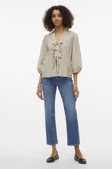 Chemise écru à manches courtes de VERO MODA, avec un motif rayé, portée avec des jeans bleus.