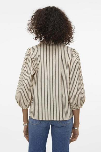 Ecru hemd met korte mouwen van VERO MODA®, met een gestreept patroon, gedragen met blauwe jeans.
