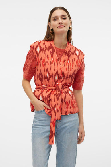 Gilet orange VERO MODA, avec motif ikat, manches côtelées et ceinture, vu de derrière, associé à un jean.