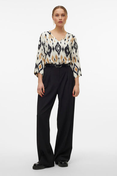 Blouse multicolore de VERO MODA avec imprimé ikat, manches trois-quarts et une jupe noire à ceinture.