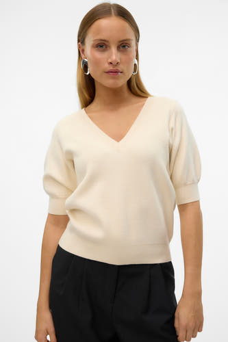 Veste écru avec col V de VERO MODA, à manches courtes et portée avec un pantalon noir et des boucles d'oreilles argentées.
