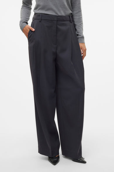 Pantalon gris de VERO MODA, vu de l'arrière avec un g trui et une des des cha noir noires.