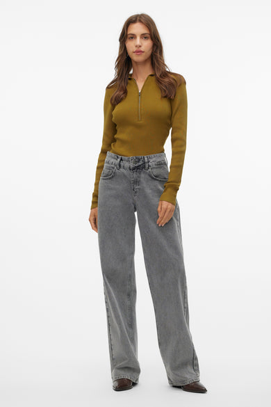 Groene trui van VERO MODA met lange mouwen en ritssluiting, gecombineerd met grijze jeans en bruine schoenen.