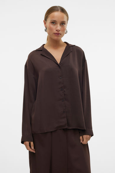 Chemise brune à manches longues de VERO MODA®, portée avec un pantalon large et des bottes.