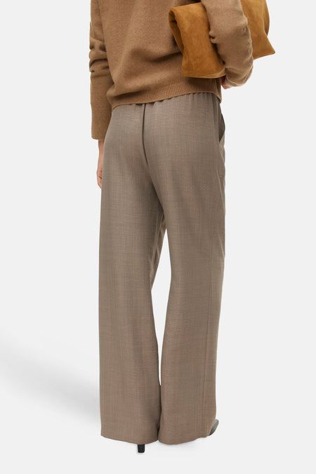 Bruine wollen pantalon met wijde pijpen en bruine trui.