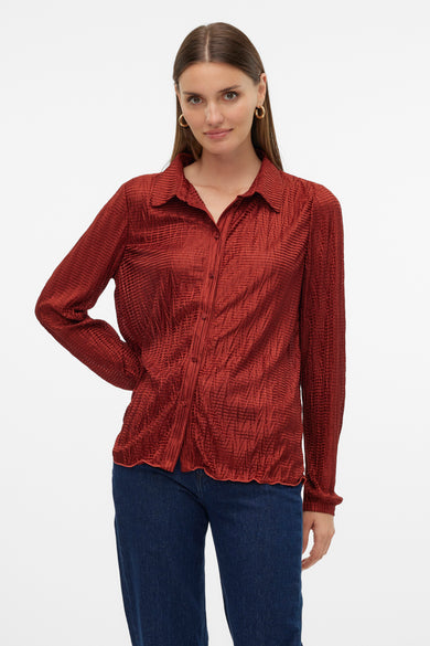 T-shirt rouge à manches longues de VERO MODA, avec une texture froissée, porté avec un jean brut.