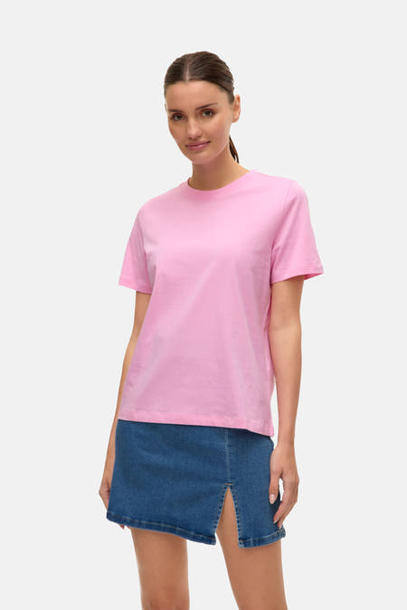 T-shirt rose à manches courtes de VERO MODA, associé à une jupe en denim bleu avec une fente.