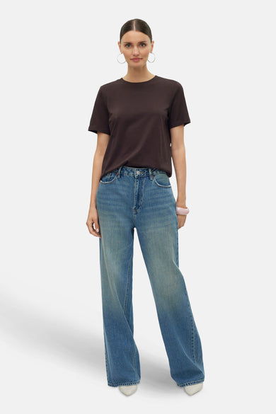 T-shirt marron à manches courtes de VERO MODA®, associé à des jeans bleus et des boucles d'oreilles argentées.