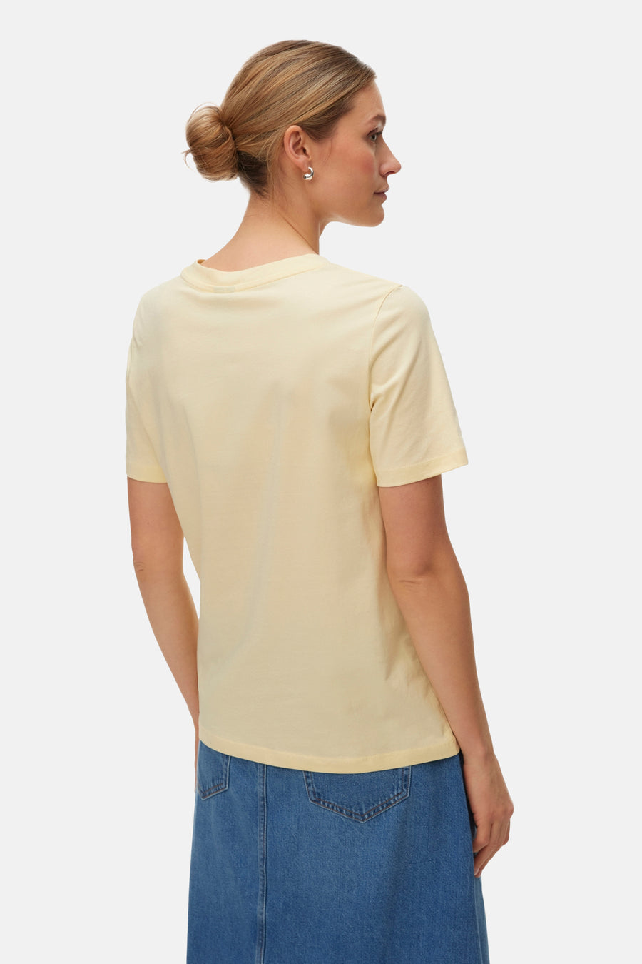 T-shirt à manches courtes jaune de Vero Moda, vu de dos, combiné avec une jupe bleue.