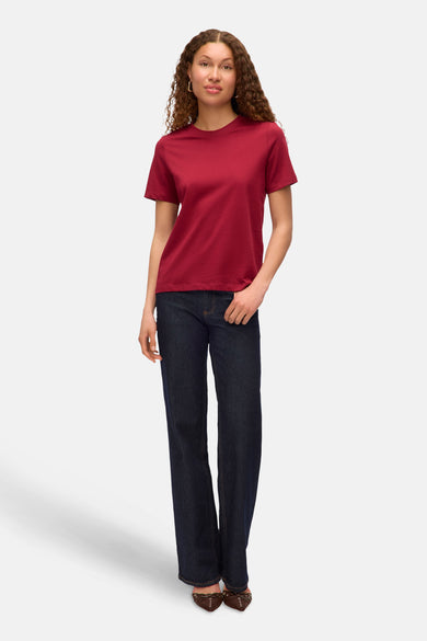 T-shirt rouge à manches courtes de VERO MODA, associé à des jeans bleu marine et des chaussures marron.