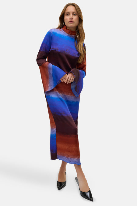 Doudoune multicolore à longues manches de VERO MODA, avec une transition de couleurs frappante et des manches bouffantes, portée avec des escarpins noirs.