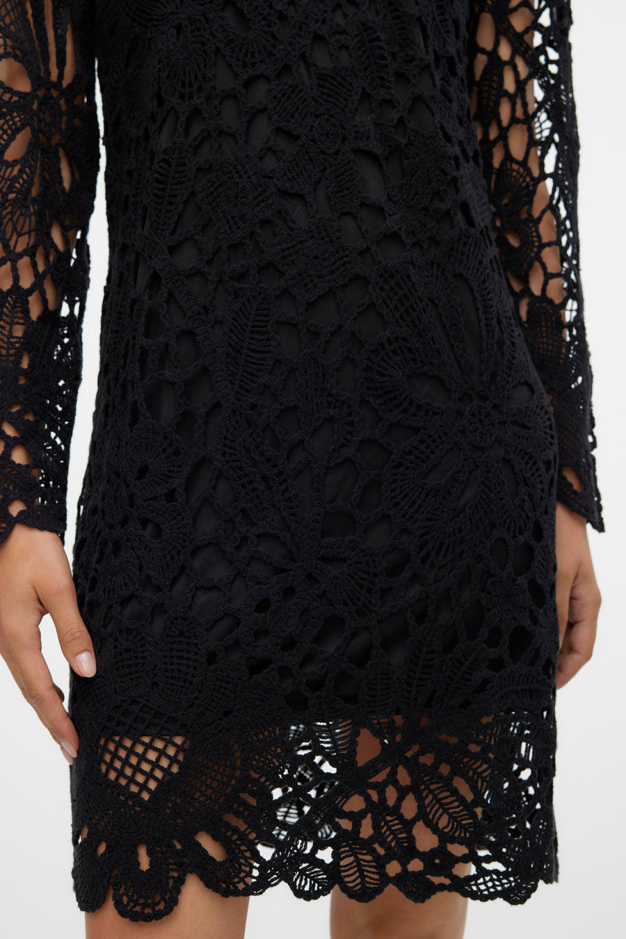 Zwarte gehaakte jurk met lange mouwen.
