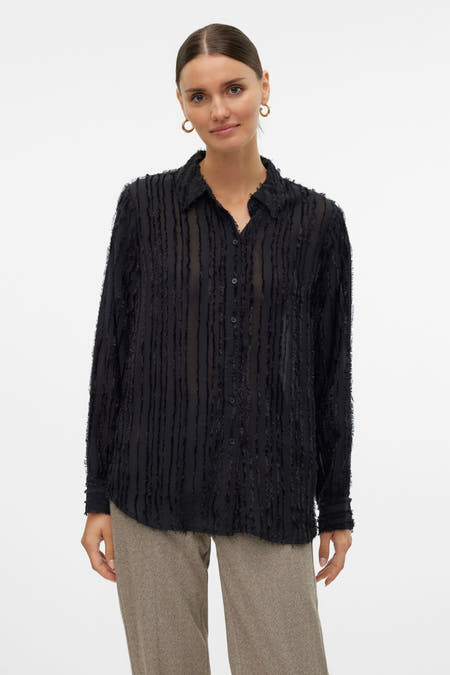 Chemise noire à manches longues de VERO MODA®, avec des rayures et portée avec un pantalon marron.