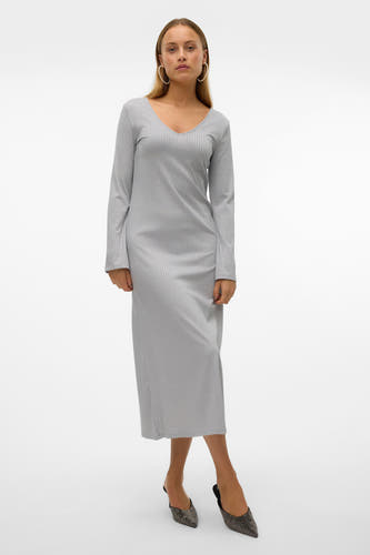 Longue robe grise de VERO MODA, avec des manches longues et un col en V, portée avec des talons noirs.