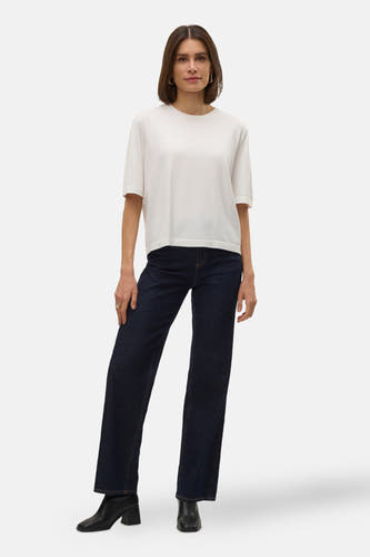 Pull blanc à col rond de VERO MODA®, combiné avec un jean foncé et des bottines noires.
