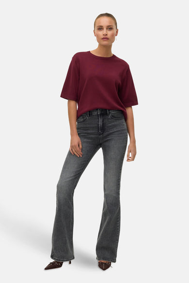 Veste Bordeaux de VERO MODA avec col rond, portée avec des jeans gris et des baskets brunes décorées.