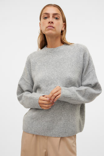 Sweat-shirt gris avec col rond de VERO MODA, tricoté uni avec des manches longues et porté avec des boucles d'oreilles dorées.