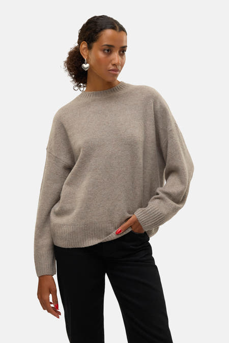Pull marron avec col rond de VERO MODA, à longues manches, associé à un pantalon noir et des boucles d'oreilles argentées.