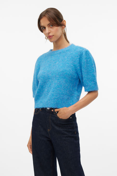 T-shirt bleu avec col rond de VERO MODA, associé à des jeans foncés et des boucles d'oreilles dorées.