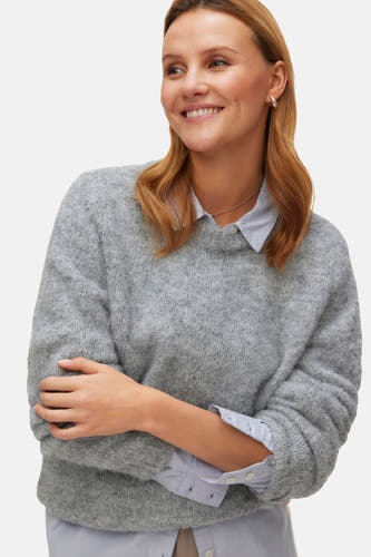 Pull rond gris Vals de Vero Moda, avec des manches longues sur un chemisier bleu clair.