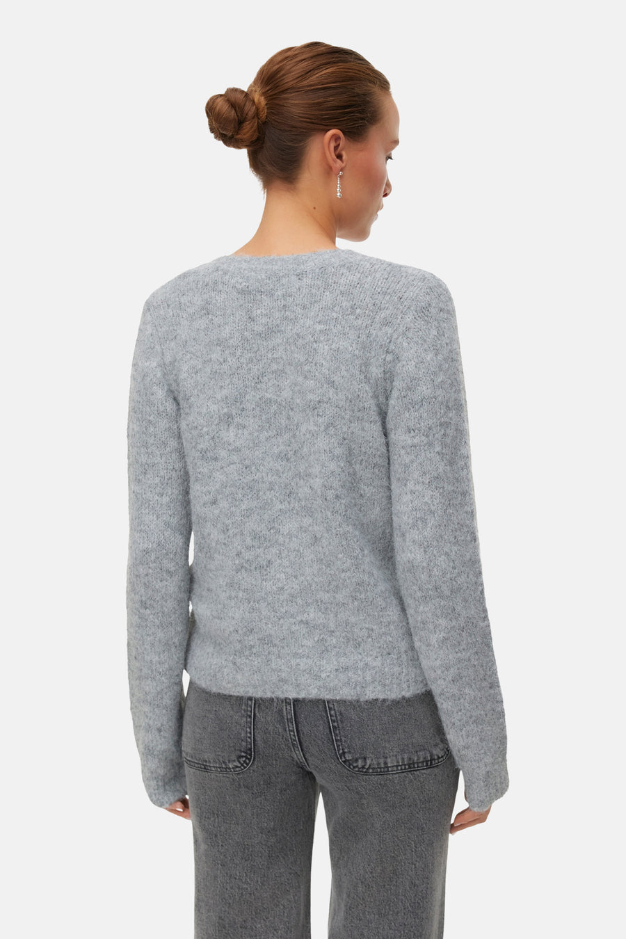 Cardigan gris de VERO MODA, avec des manches longues et une subtile texture, associé à un jean gris.