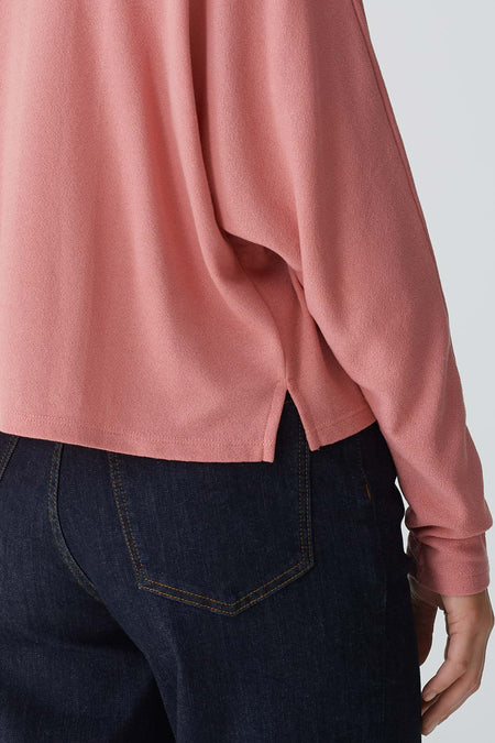 T-shirt rose avec col rond d'OPUS, avec longues manches et une fente latérale, associé à un jean bleu marine.