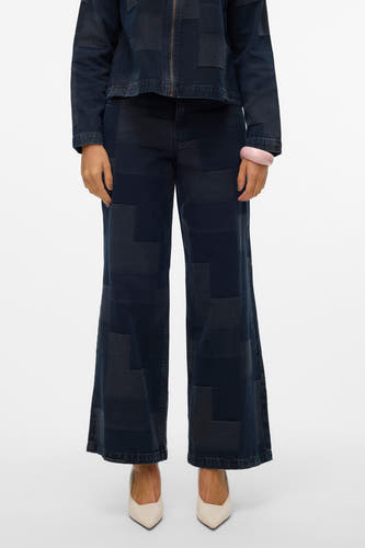 Jean décontracté de denim bleu foncé de VERO MODA, avec un motif patchwork et associé à des lacets écru et une unche rose.