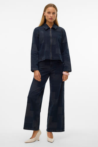 Wijde jeans van donkerblauw denim van VERO MODA, met patchwork-patroon en gecombineerd met ecrukleurige sleehakken en een roze armband.