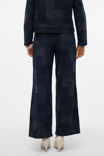 Jean large en denim bleu foncé de VERO MODA, avec des blocs de patchwork et associé à une veste.