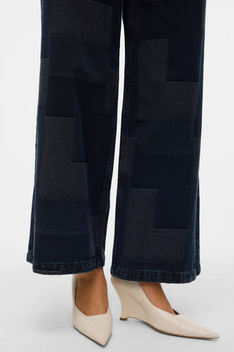 Jean délavé bleu marine de denim de VERO MODA avec motif patchwork, porté avec des escarpins crème.
